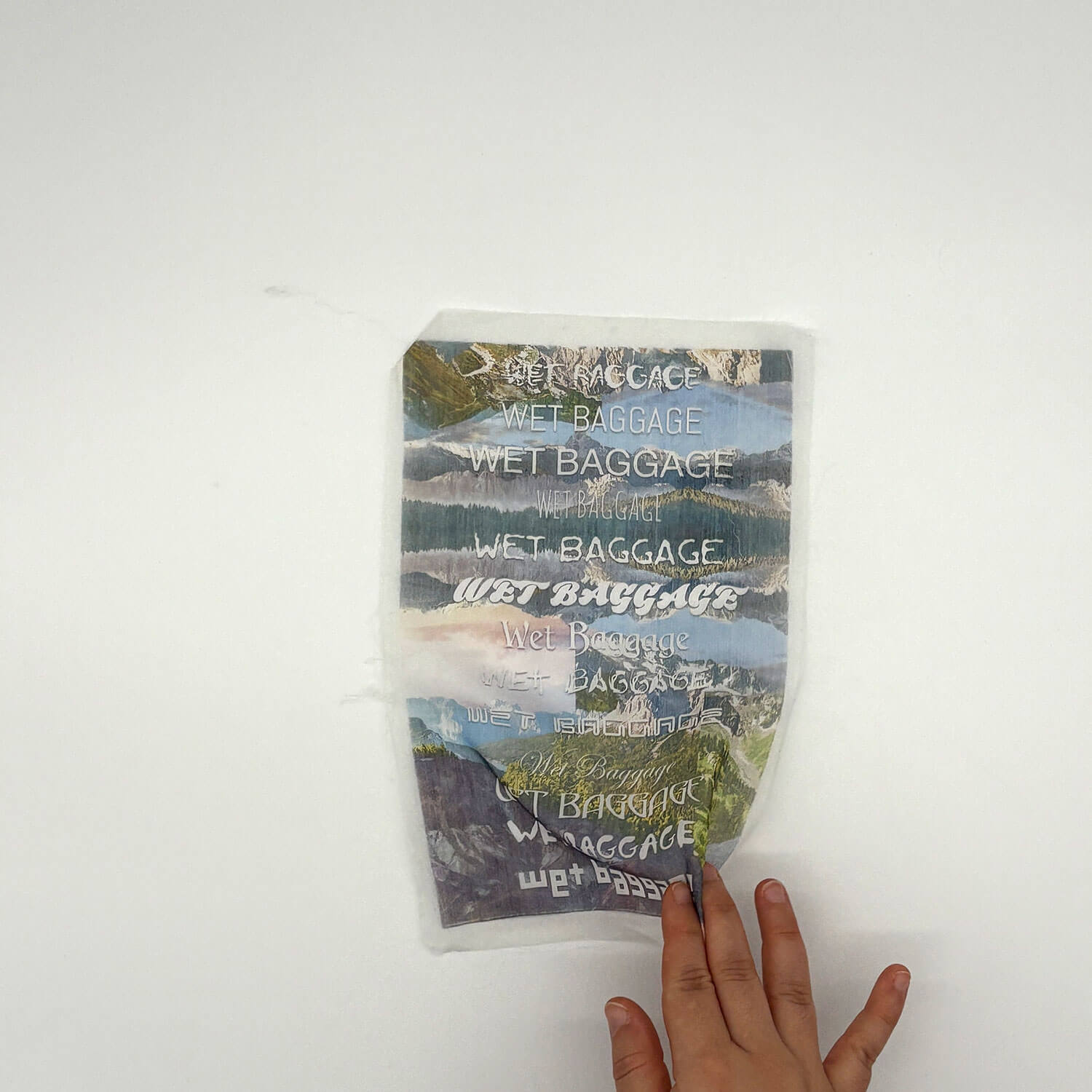 A studio photo of a designer bag and a publication printed on textile