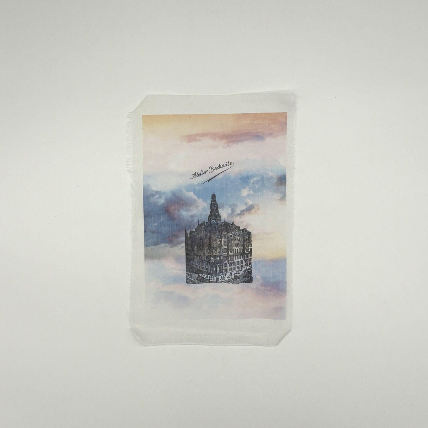 A studio photo of a designer bag and a publication printed on textile