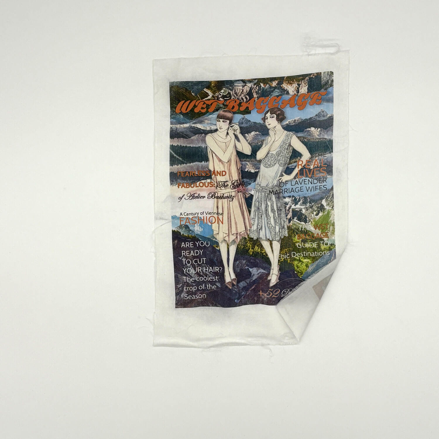 A studio photo of a designer bag and a publication printed on textile