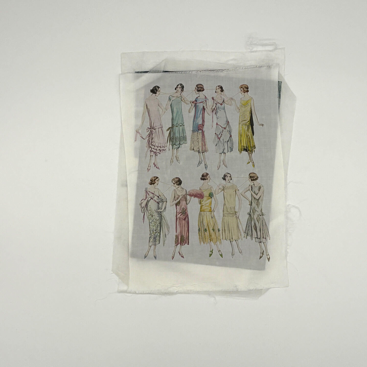 A studio photo of a designer bag and a publication printed on textile