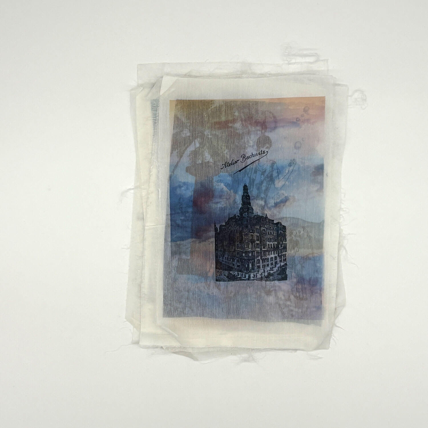 A studio photo of a designer bag and a publication printed on textile