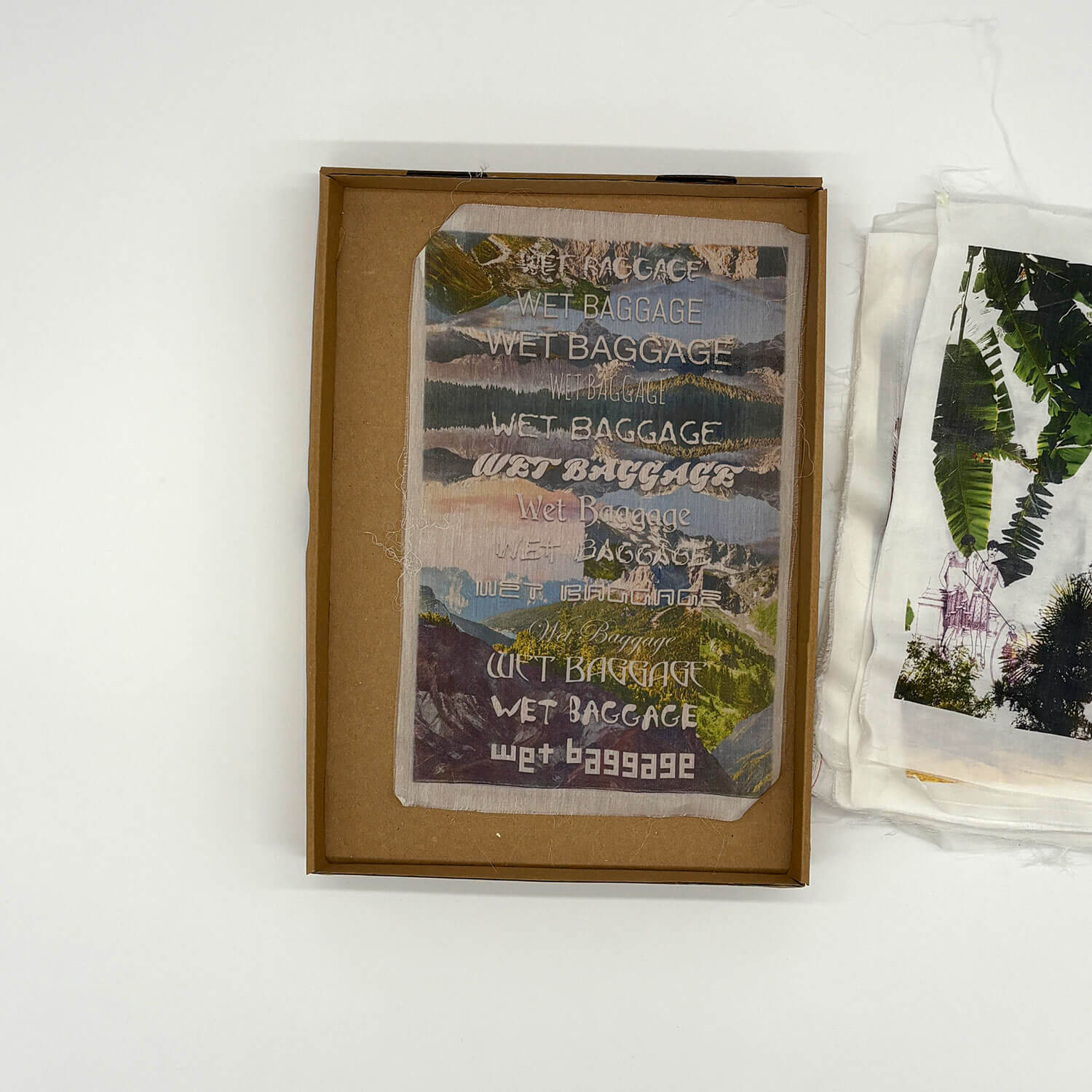 A studio photo of a designer bag and a publication printed on textile