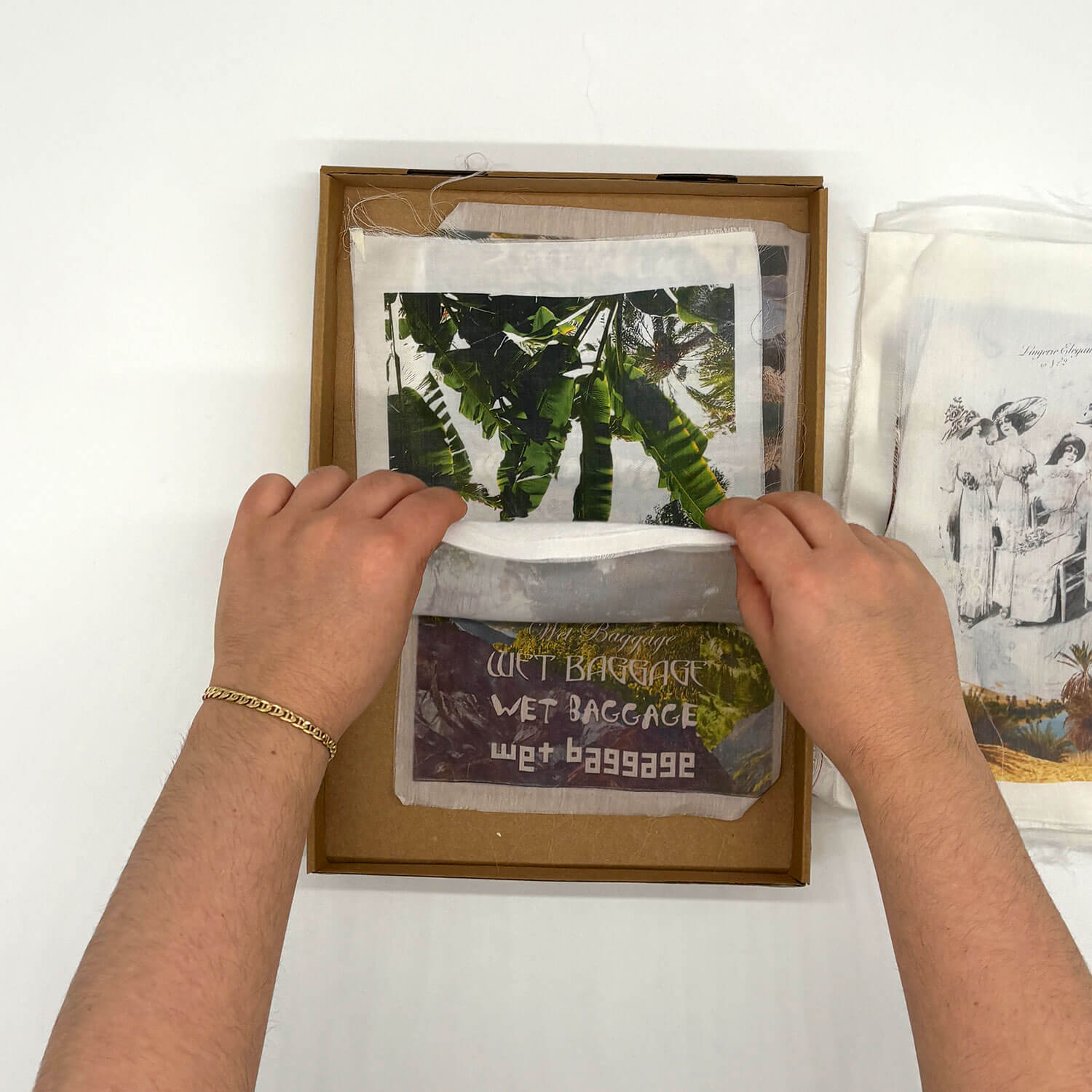 A studio photo of a designer bag and a publication printed on textile