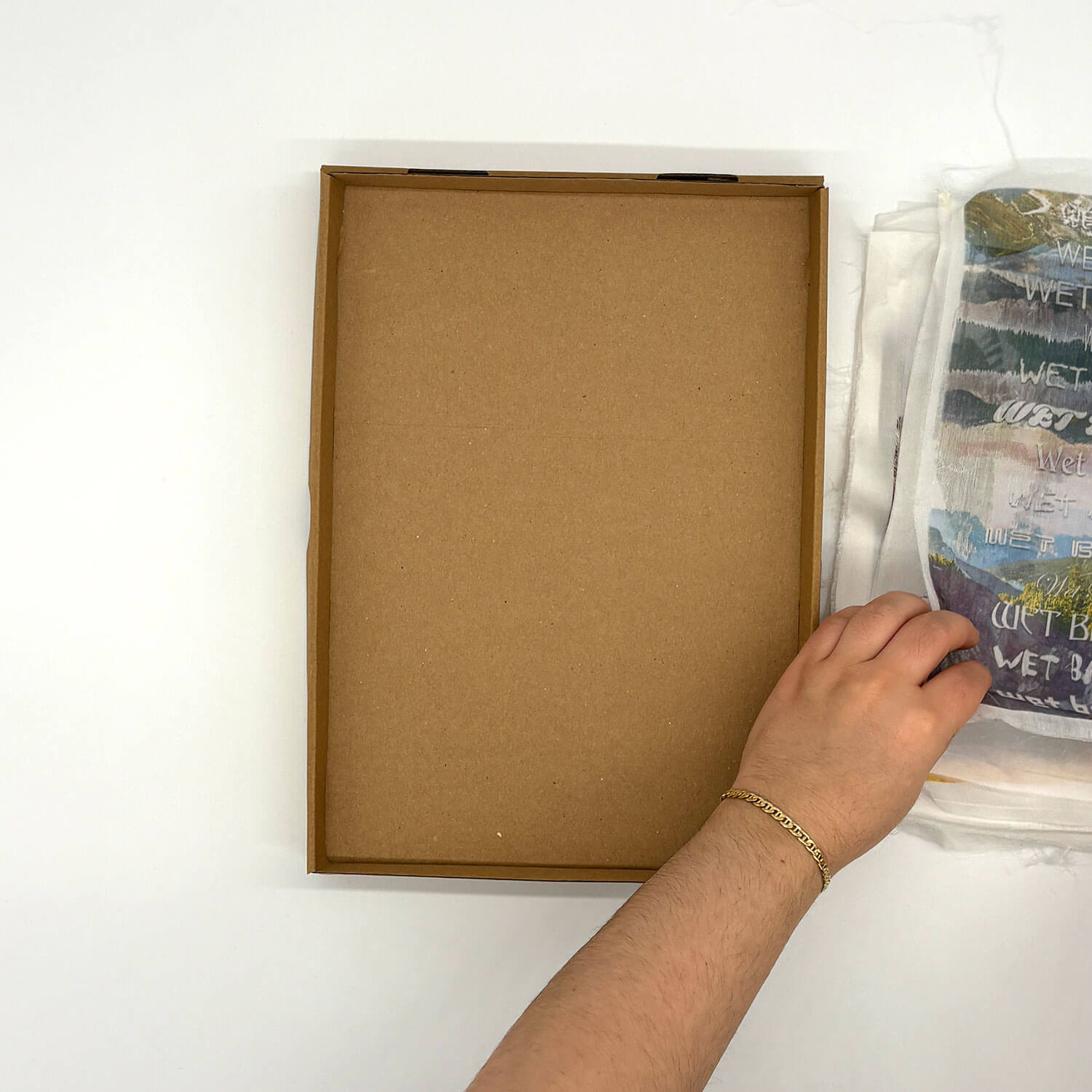 A studio photo of a designer bag and a publication printed on textile
