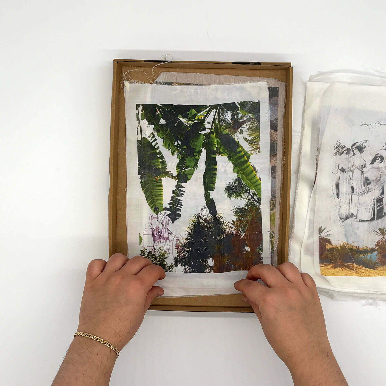 A studio photo of a designer bag and a publication printed on textile