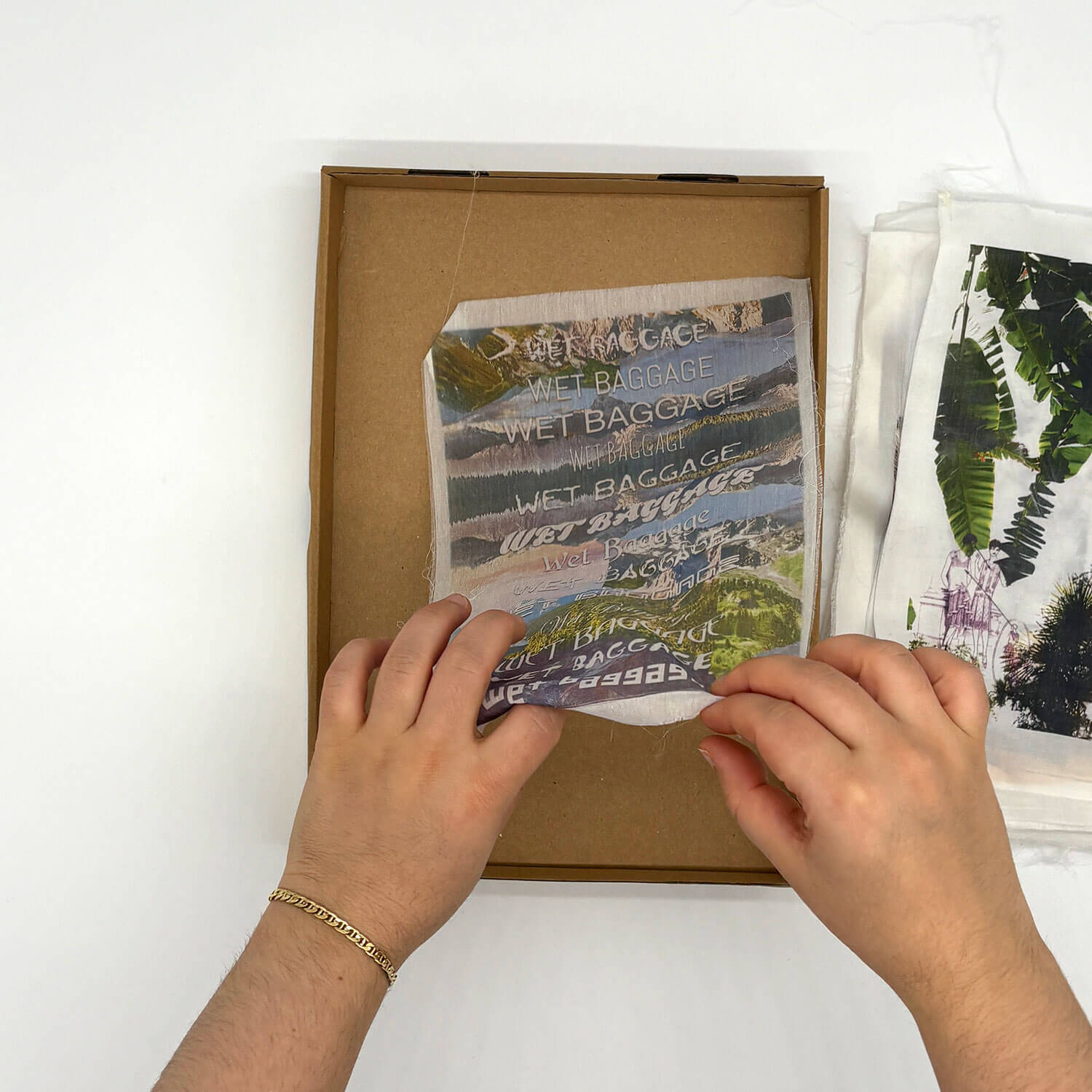 A studio photo of a designer bag and a publication printed on textile