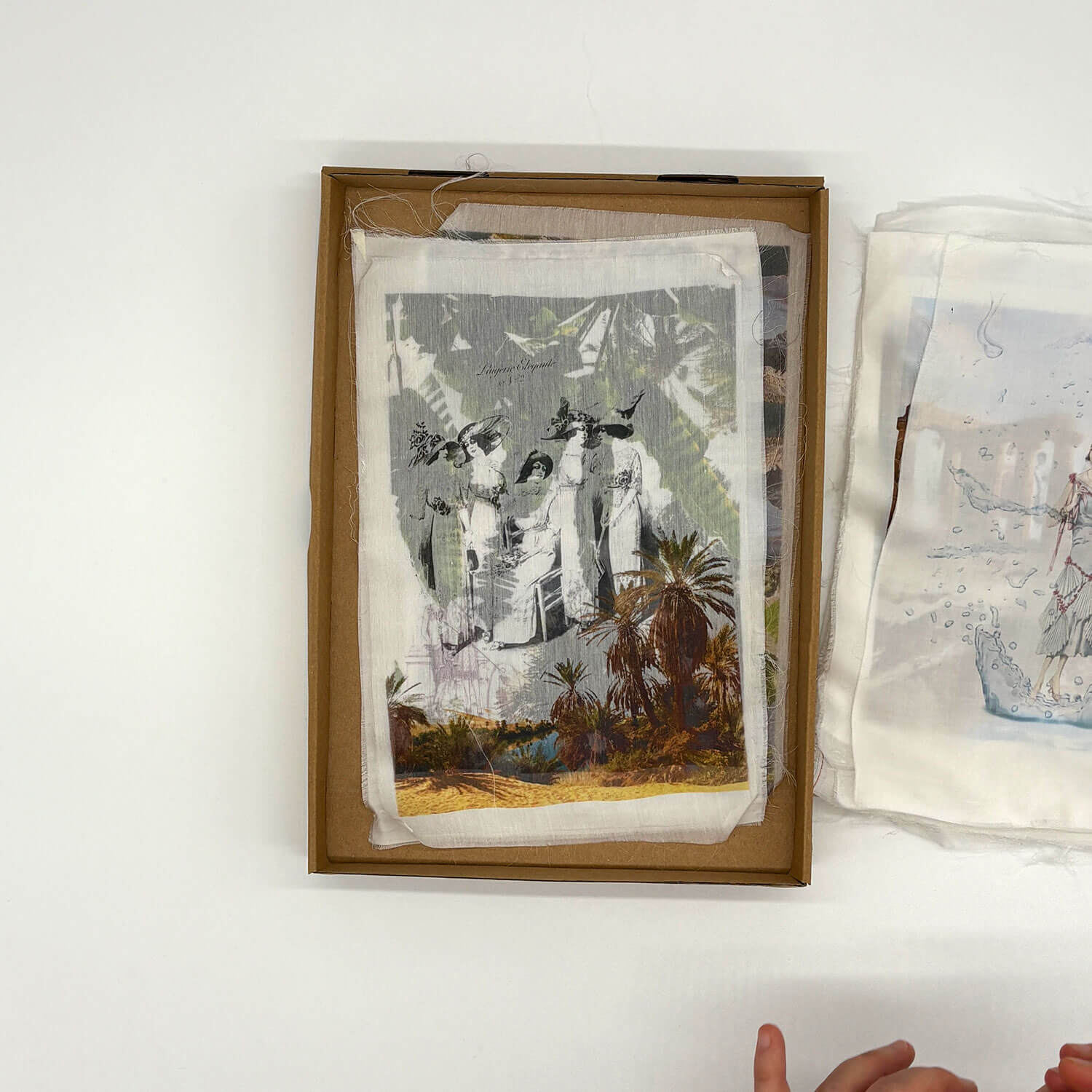 A studio photo of a designer bag and a publication printed on textile