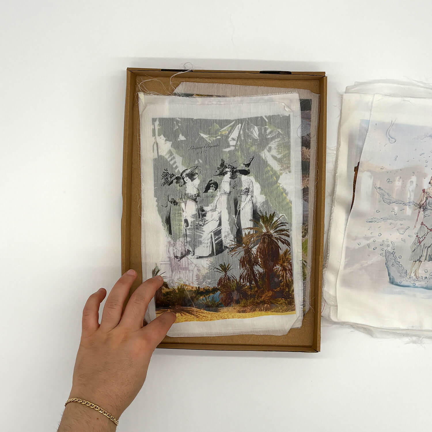 A studio photo of a designer bag and a publication printed on textile