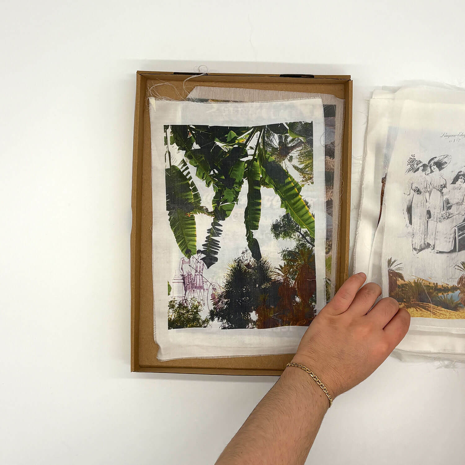 A studio photo of a designer bag and a publication printed on textile