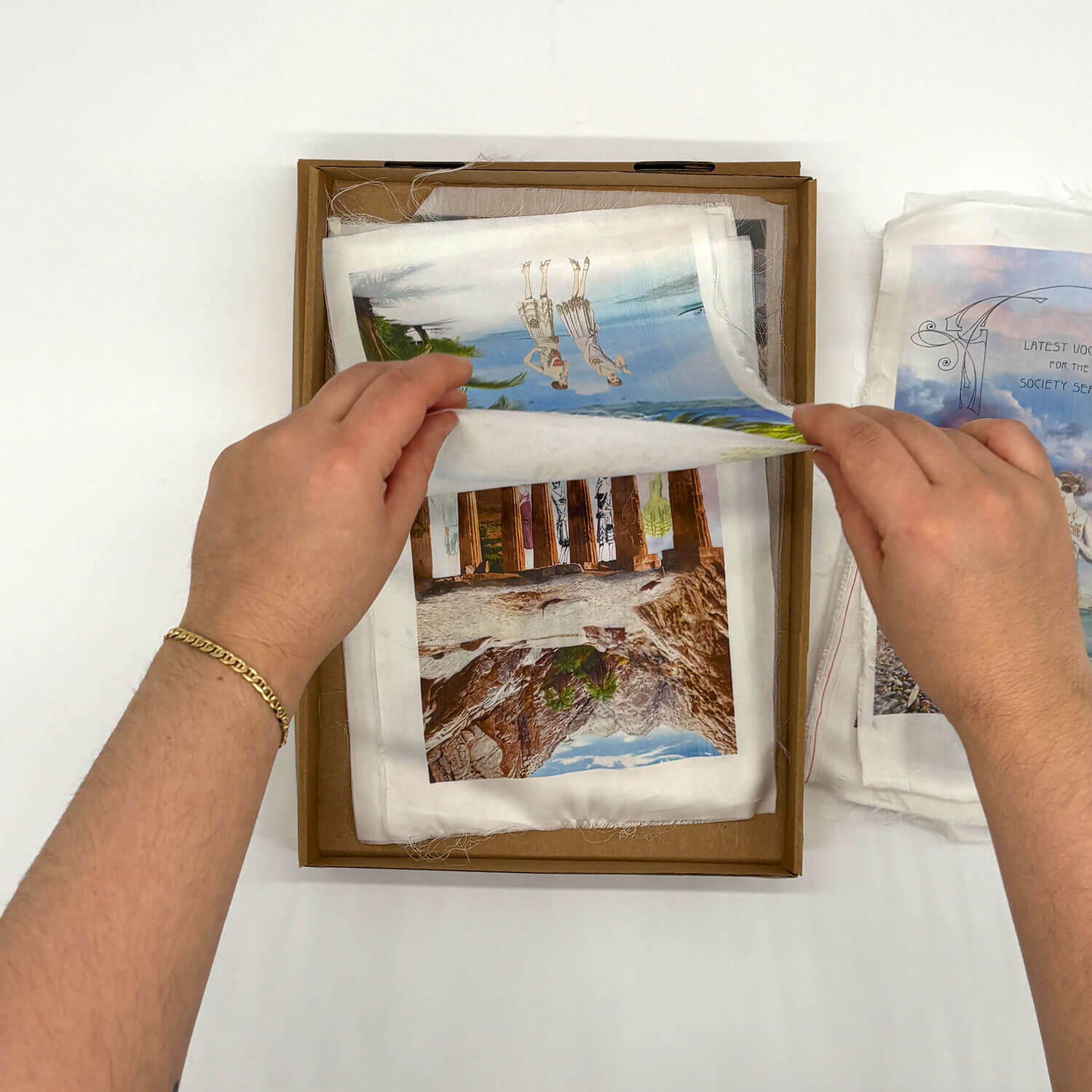 A studio photo of a designer bag and a publication printed on textile