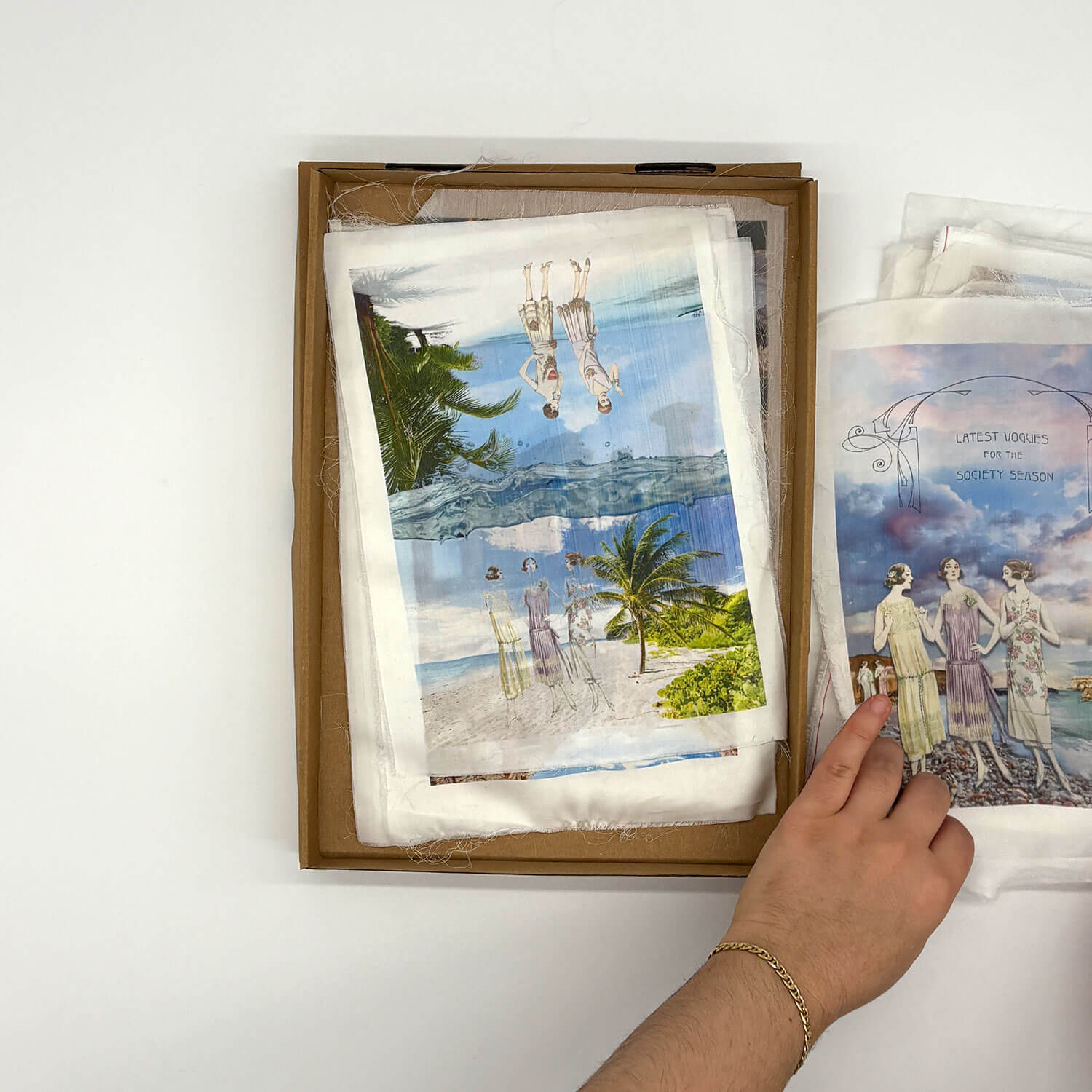 A studio photo of a designer bag and a publication printed on textile