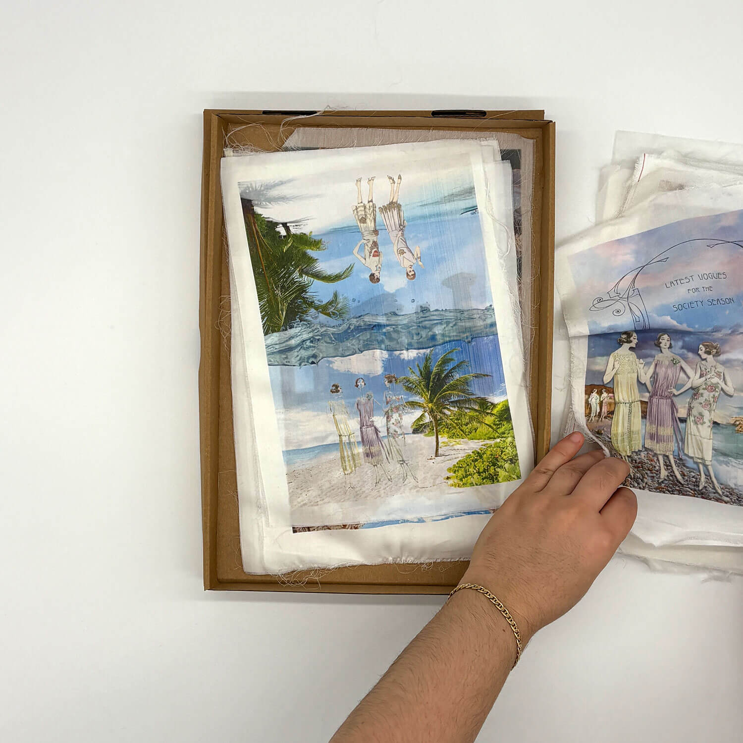 A studio photo of a designer bag and a publication printed on textile