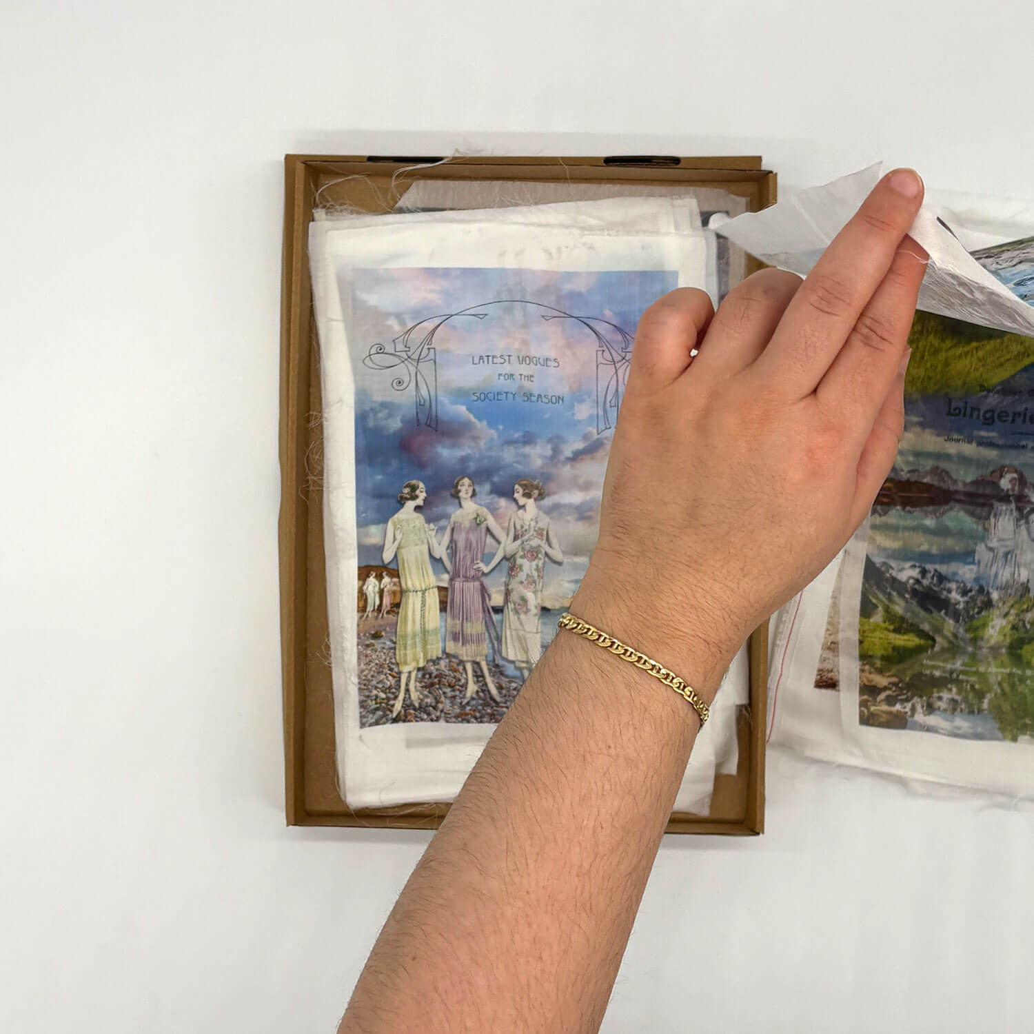 A studio photo of a designer bag and a publication printed on textile