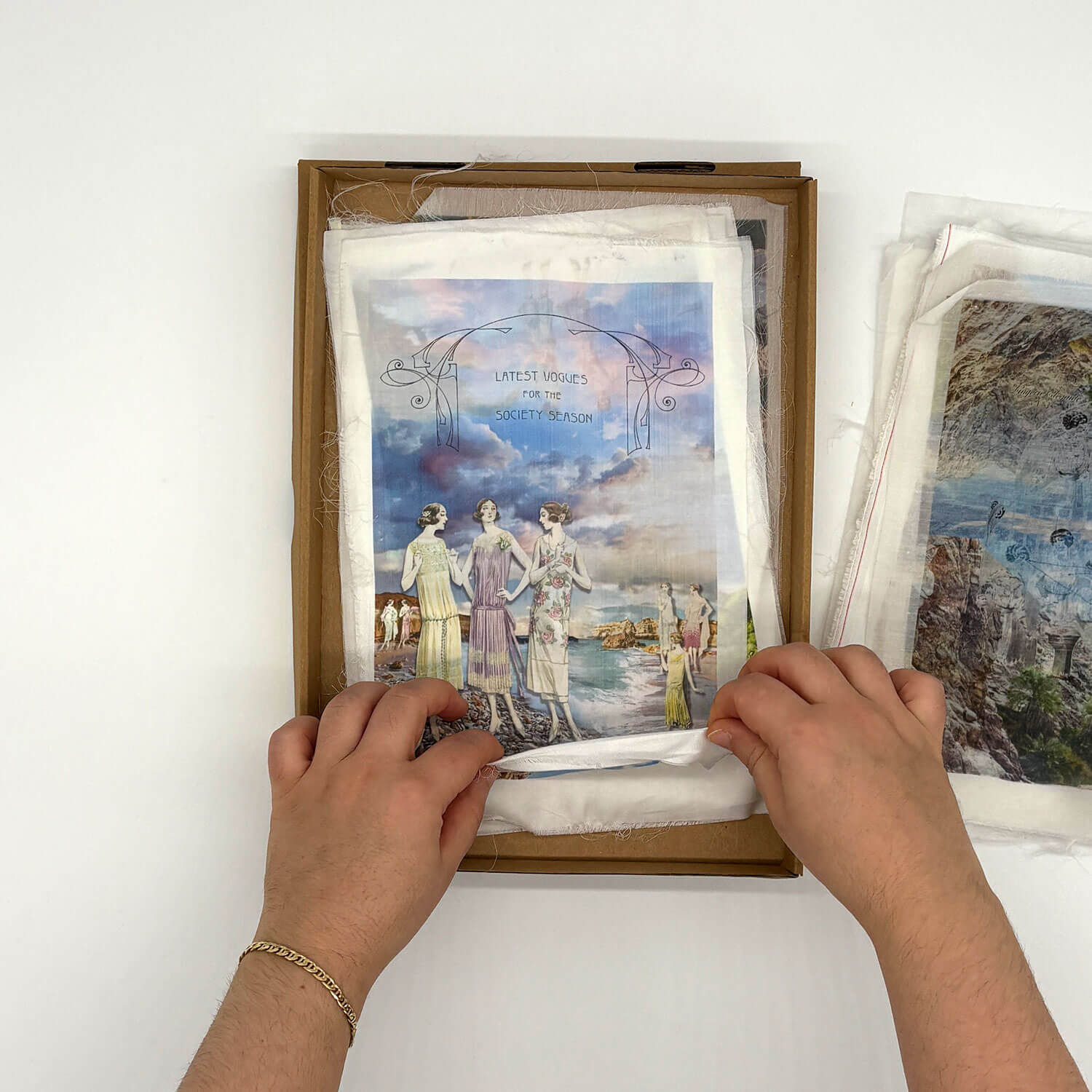 A studio photo of a designer bag and a publication printed on textile
