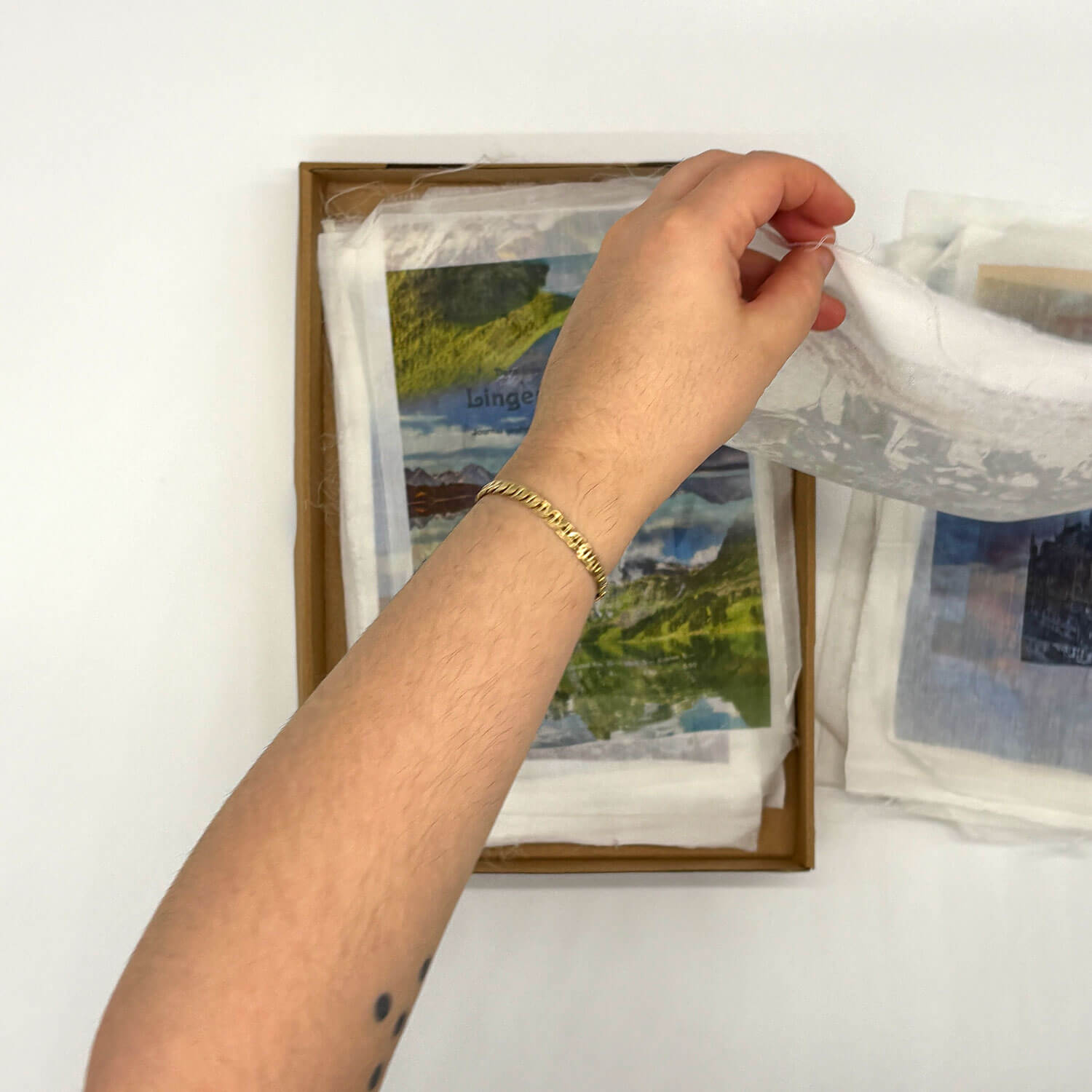 A studio photo of a designer bag and a publication printed on textile