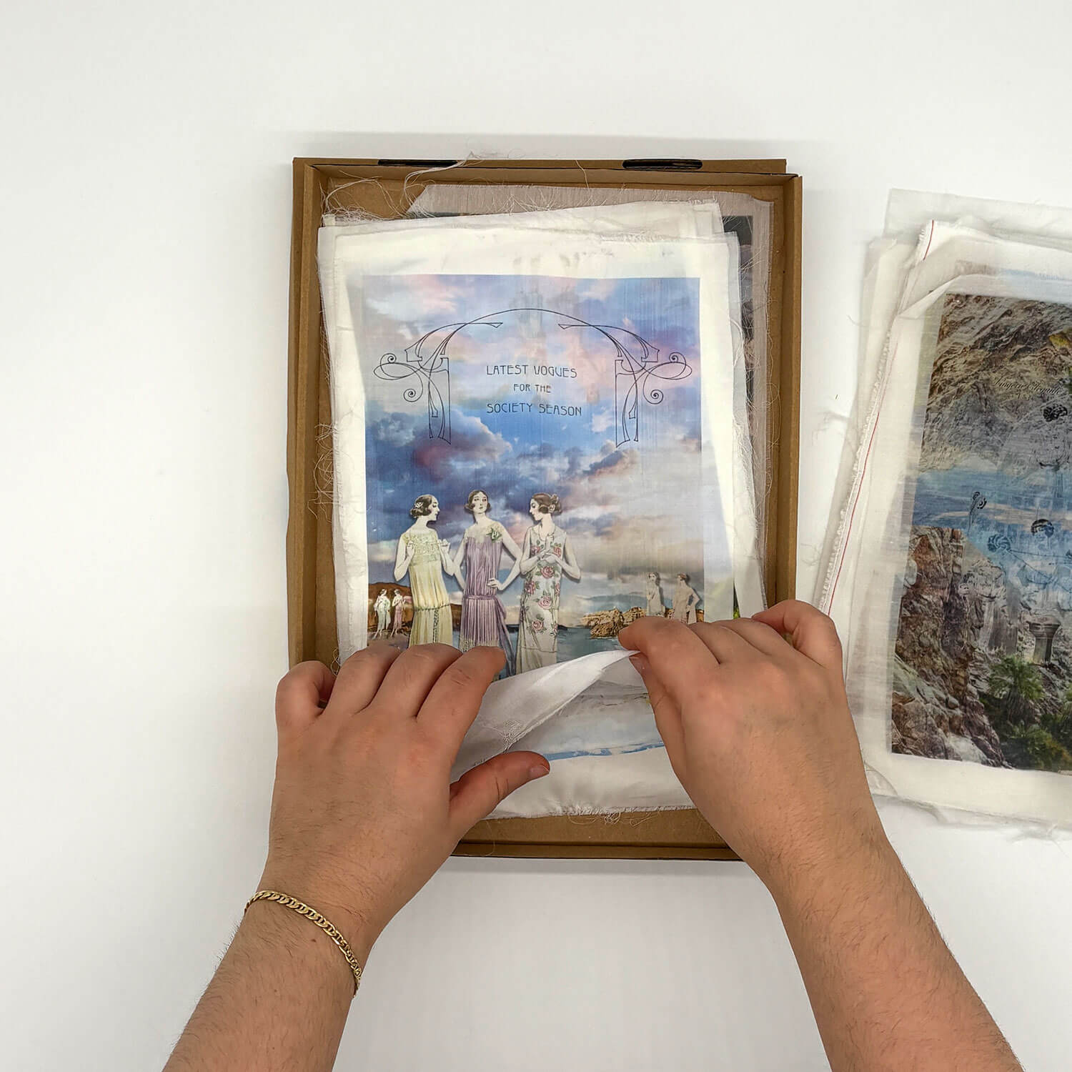 A studio photo of a designer bag and a publication printed on textile