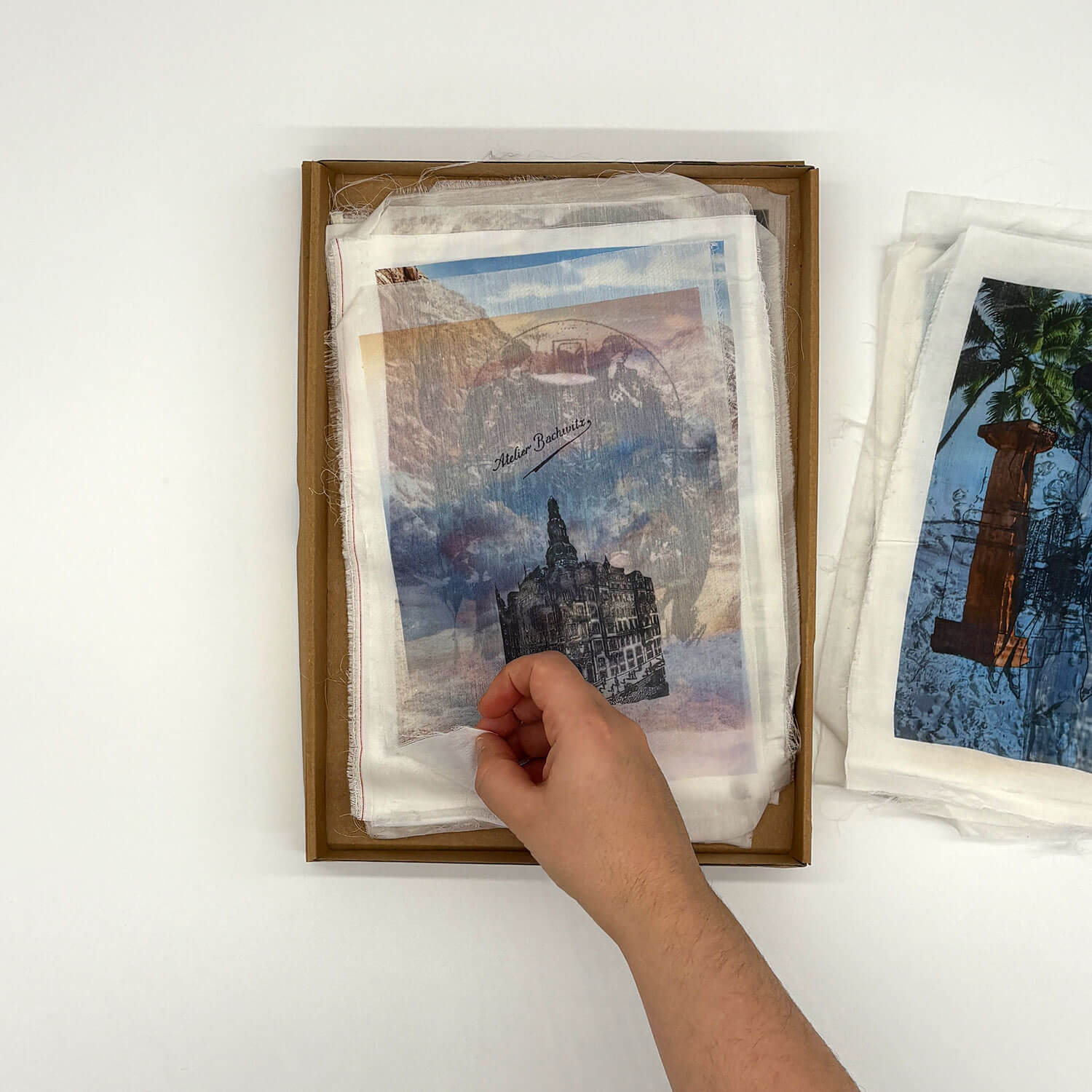 A studio photo of a designer bag and a publication printed on textile