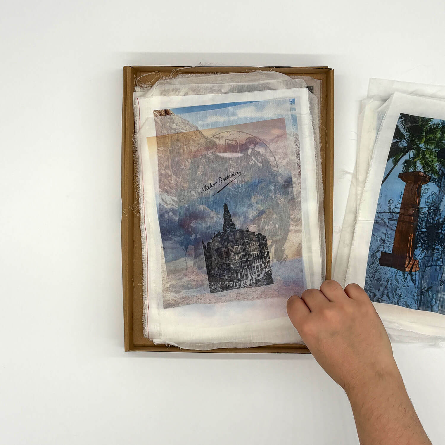 A studio photo of a designer bag and a publication printed on textile