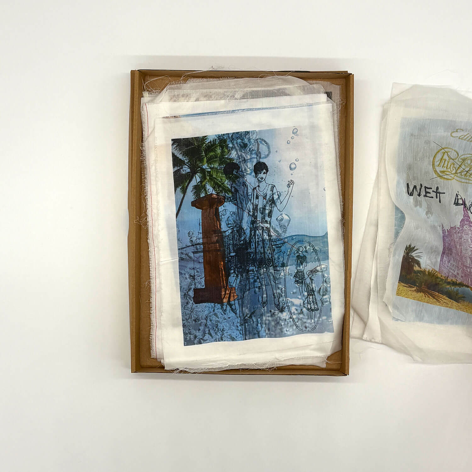 A studio photo of a designer bag and a publication printed on textile