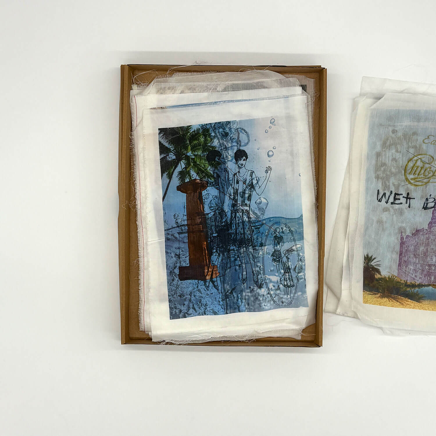 A studio photo of a designer bag and a publication printed on textile