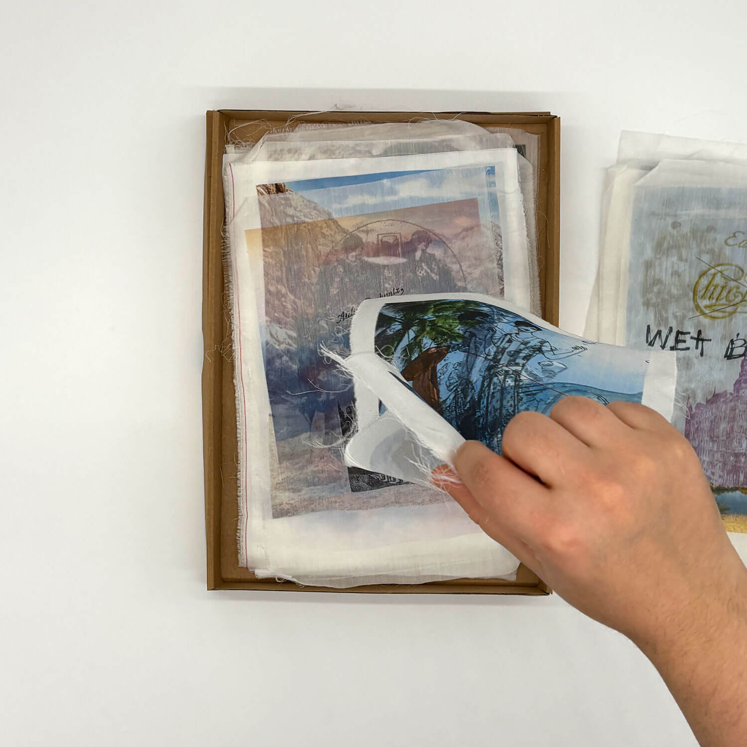 A studio photo of a designer bag and a publication printed on textile
