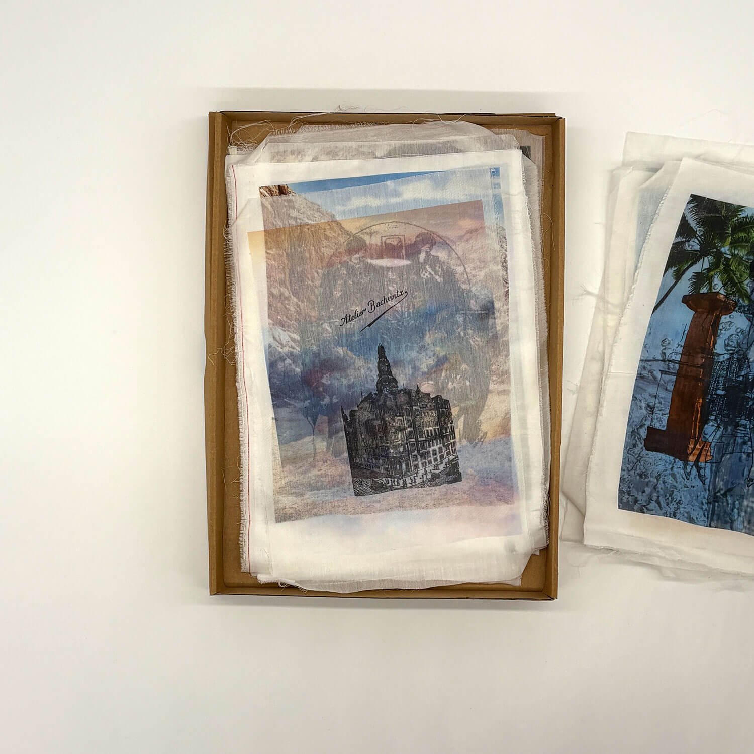 A studio photo of a designer bag and a publication printed on textile