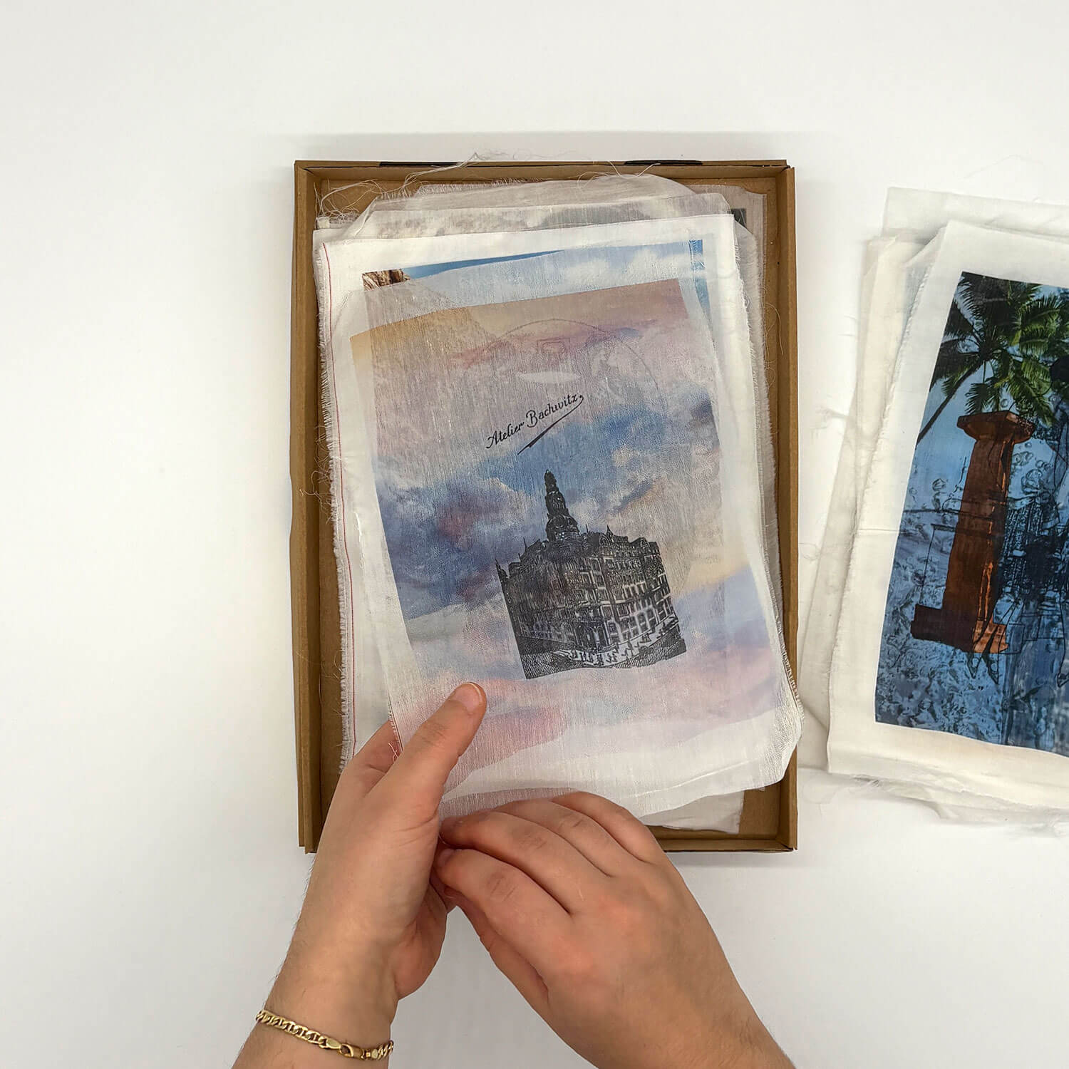 A studio photo of a designer bag and a publication printed on textile