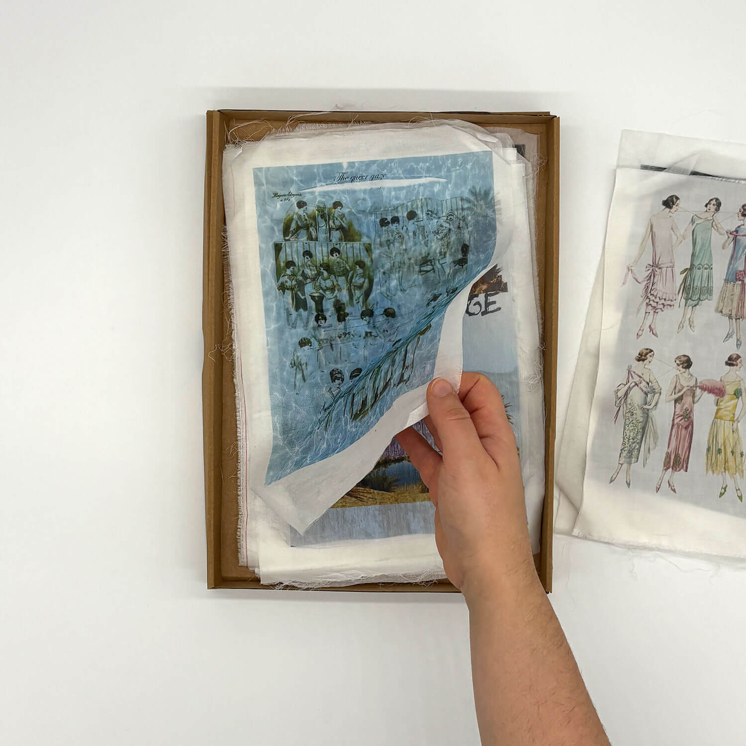 A studio photo of a designer bag and a publication printed on textile