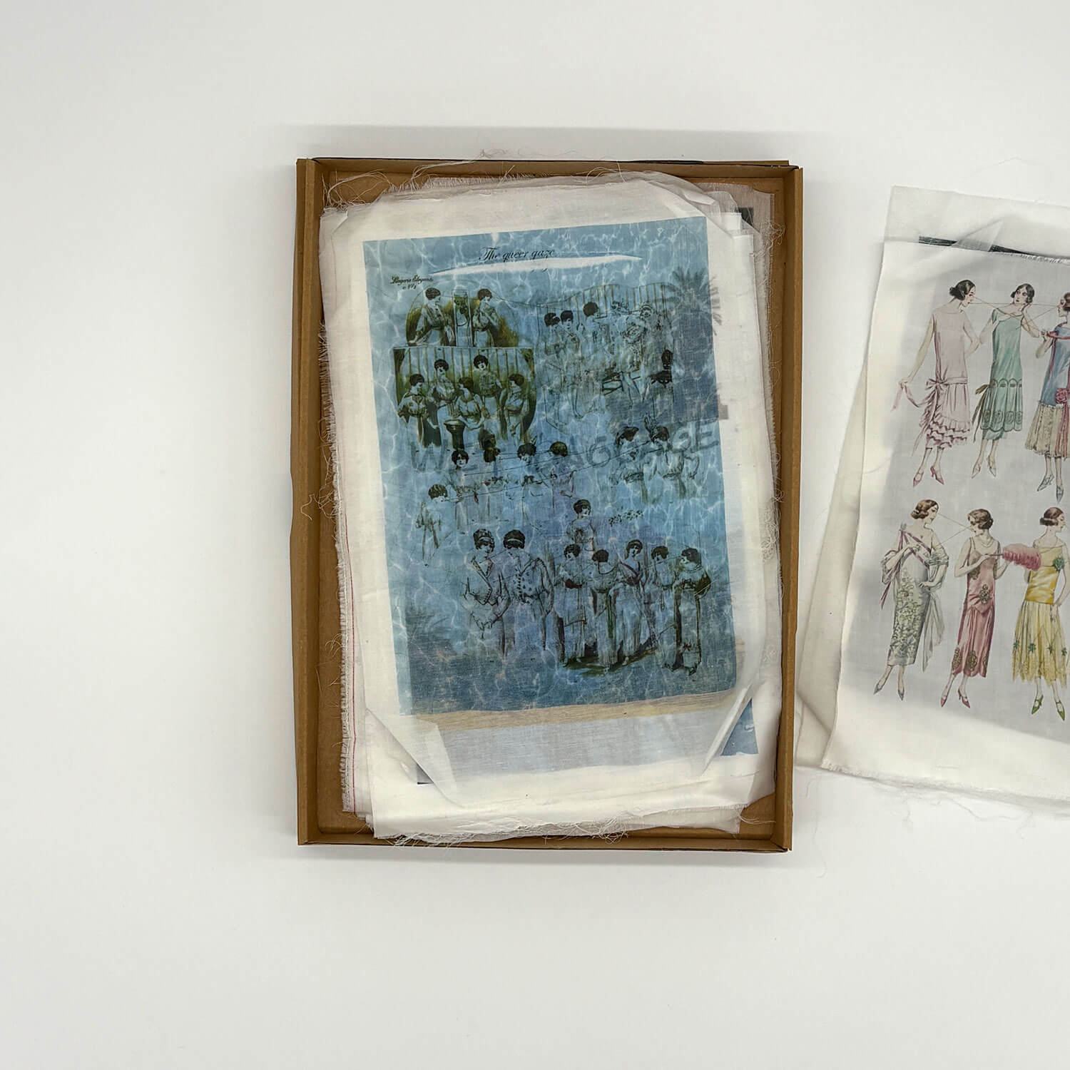 A studio photo of a designer bag and a publication printed on textile