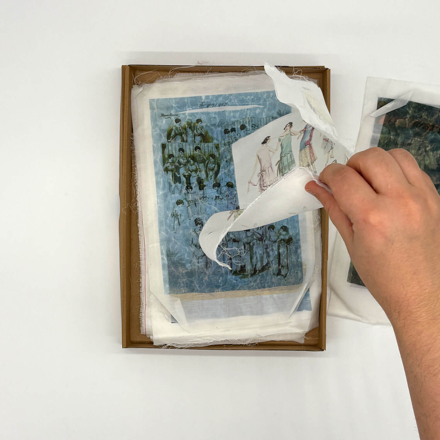 A studio photo of a designer bag and a publication printed on textile