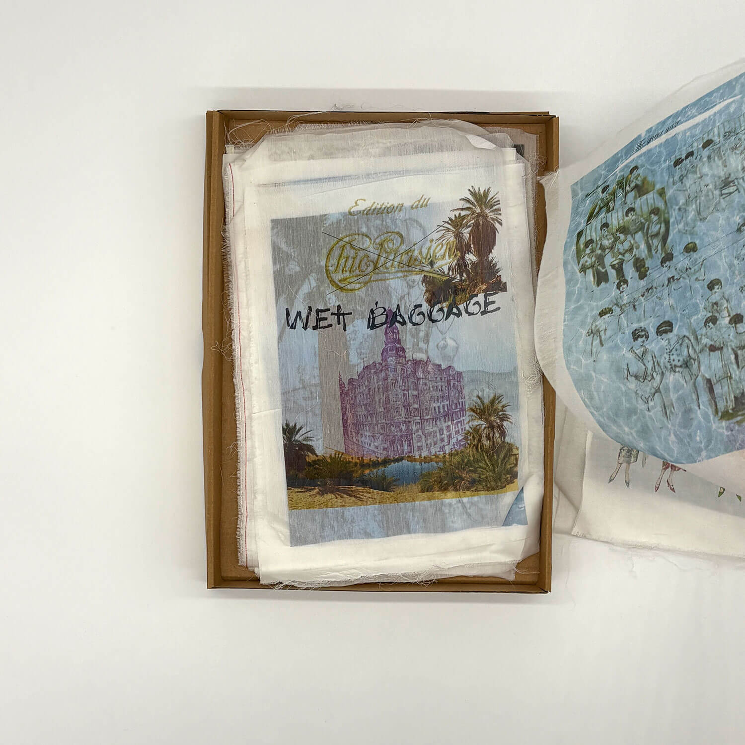 A studio photo of a designer bag and a publication printed on textile