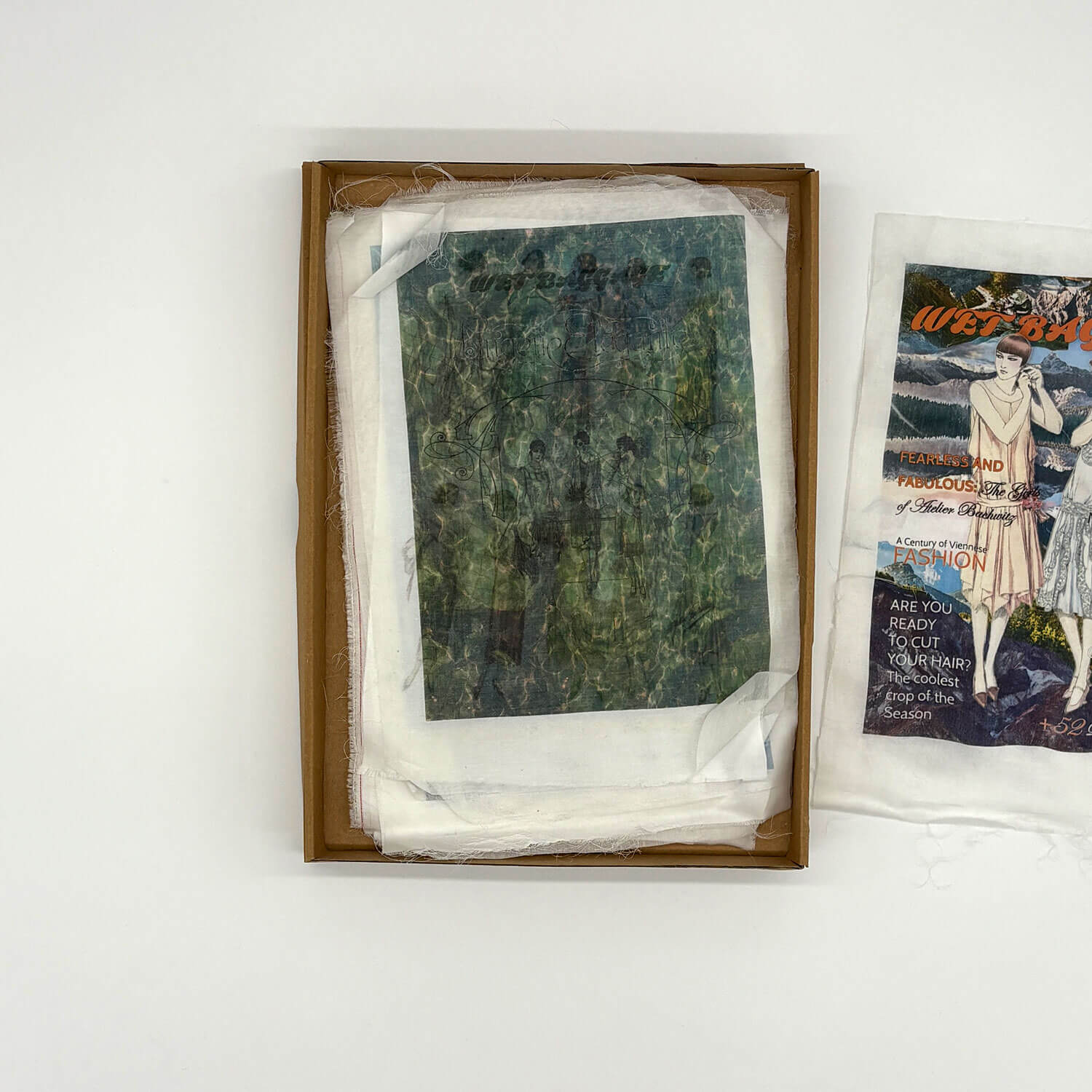 A studio photo of a designer bag and a publication printed on textile