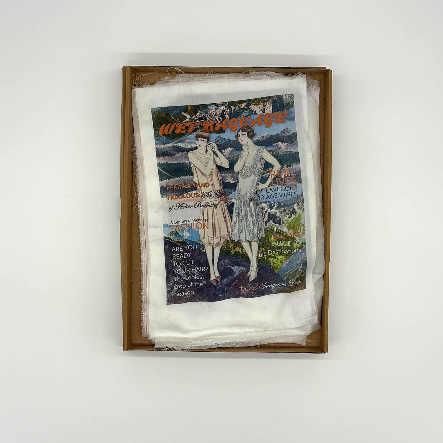 A studio photo of a designer bag and a publication printed on textile