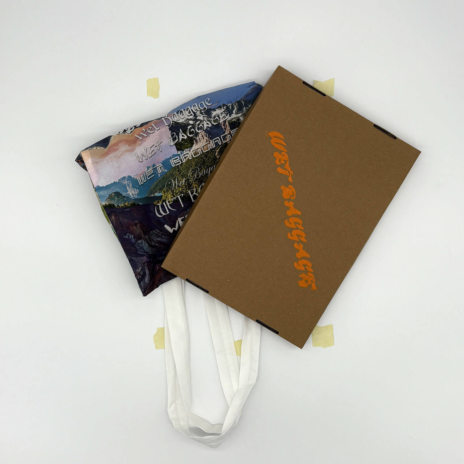 A studio photo of a designer bag and a publication printed on textile