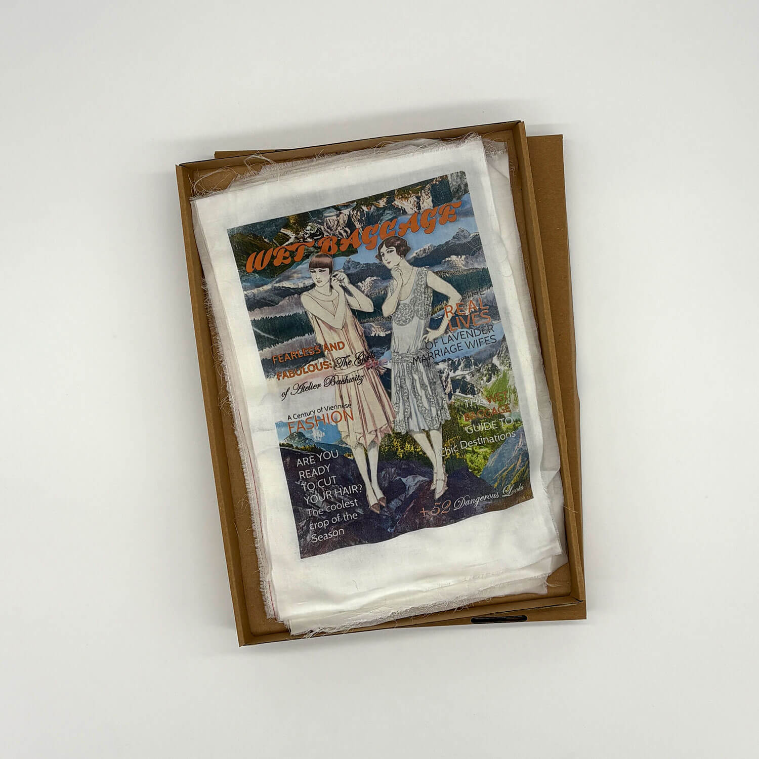 A studio photo of a designer bag and a publication printed on textile