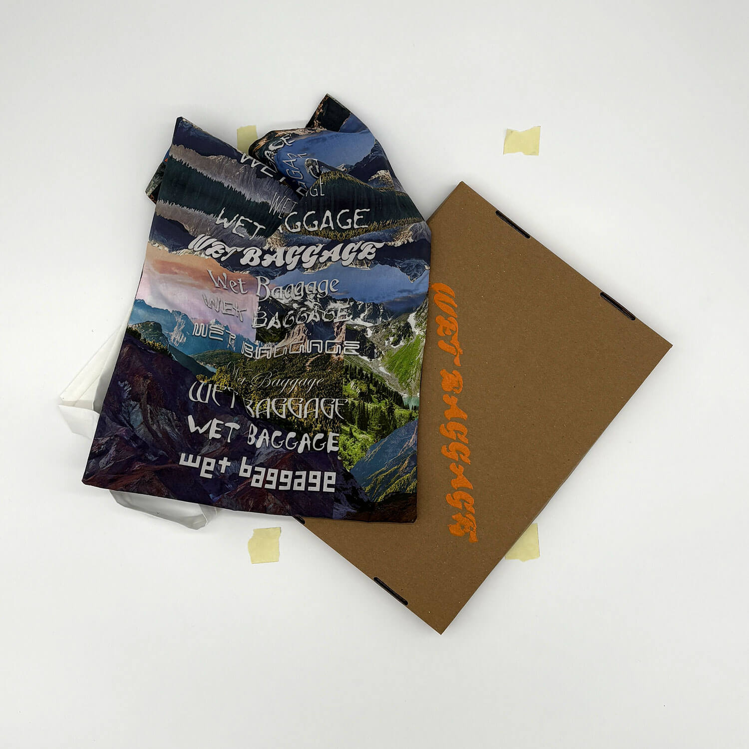 A studio photo of a designer bag and a publication printed on textile