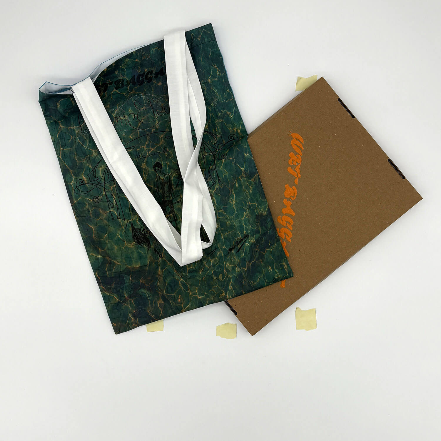 A studio photo of a designer bag and a publication printed on textile