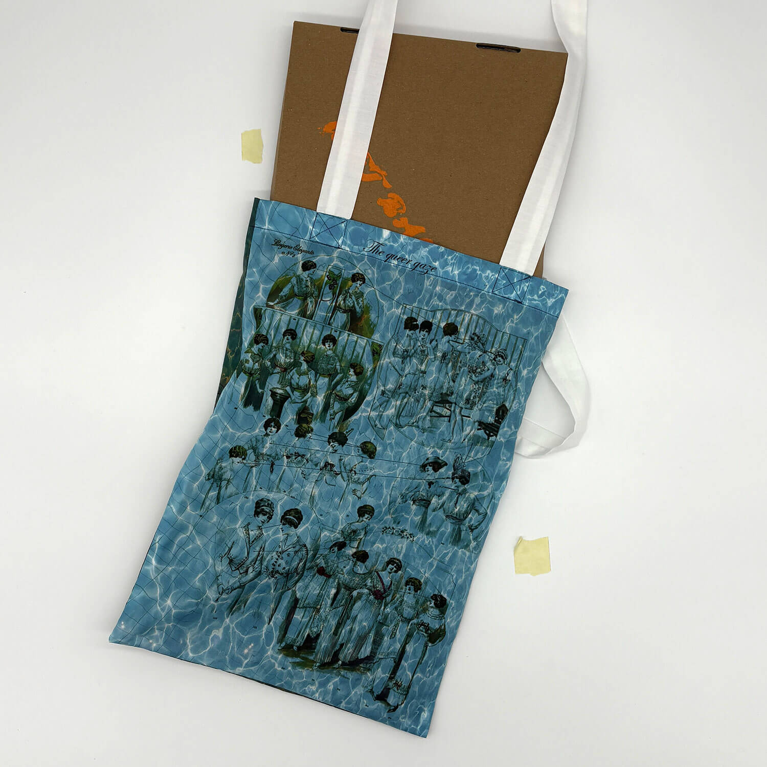 A studio photo of a designer bag and a publication printed on textile