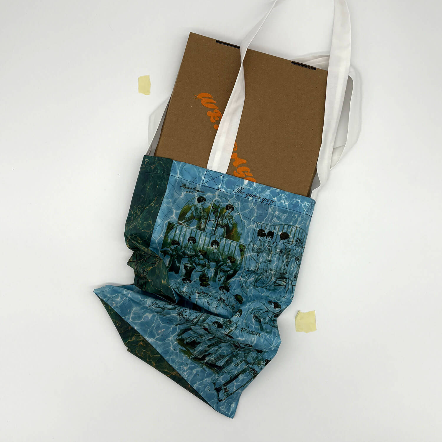 A studio photo of a designer bag and a publication printed on textile