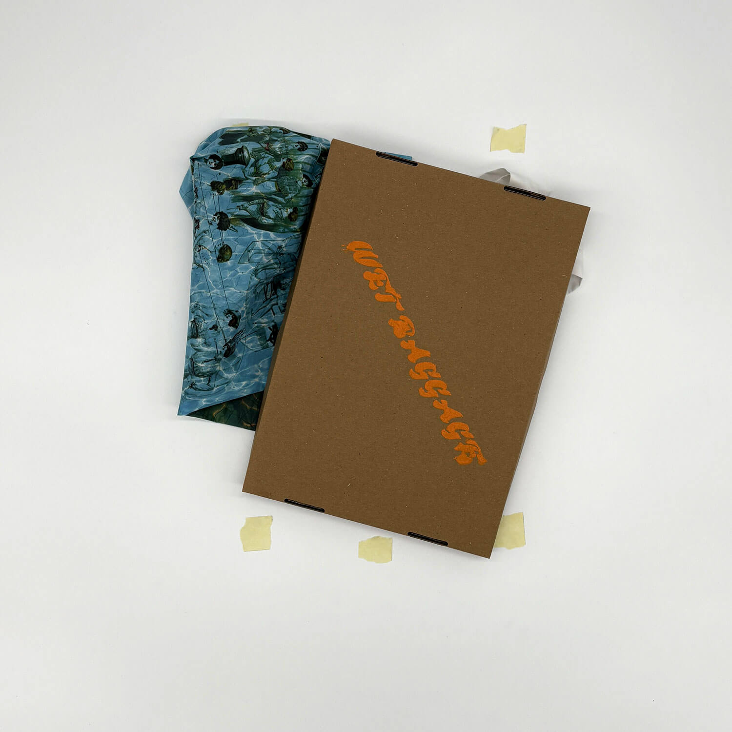 A studio photo of a designer bag and a publication printed on textile