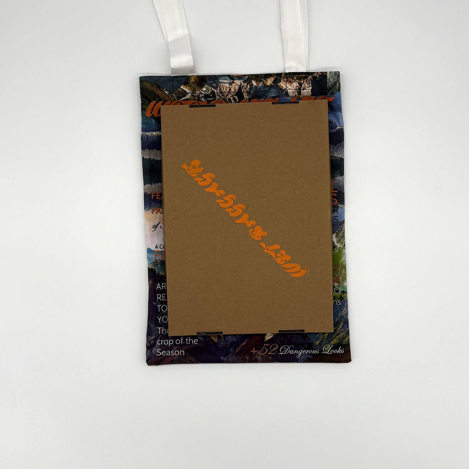A studio photo of a designer bag and a publication printed on textile