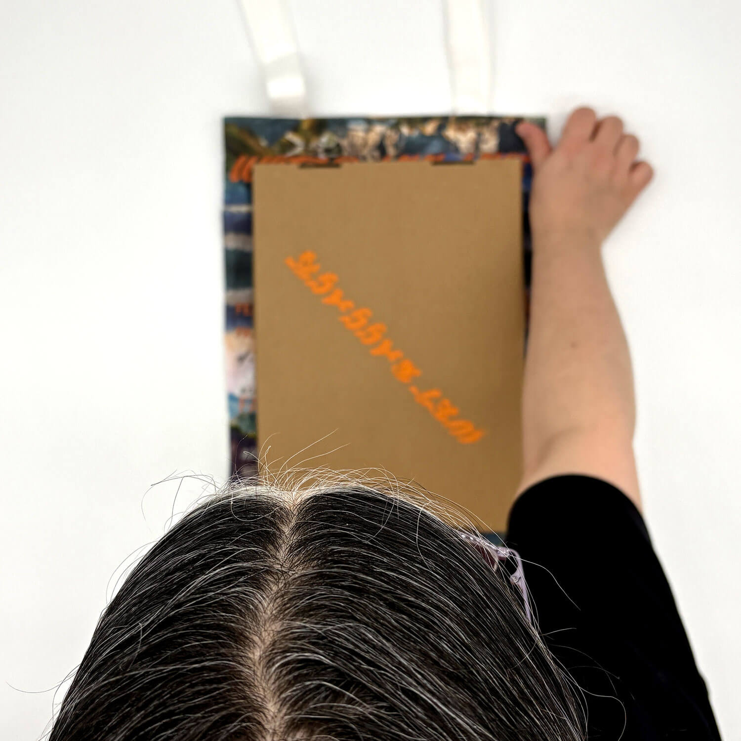 A studio photo of a designer bag and a publication printed on textile