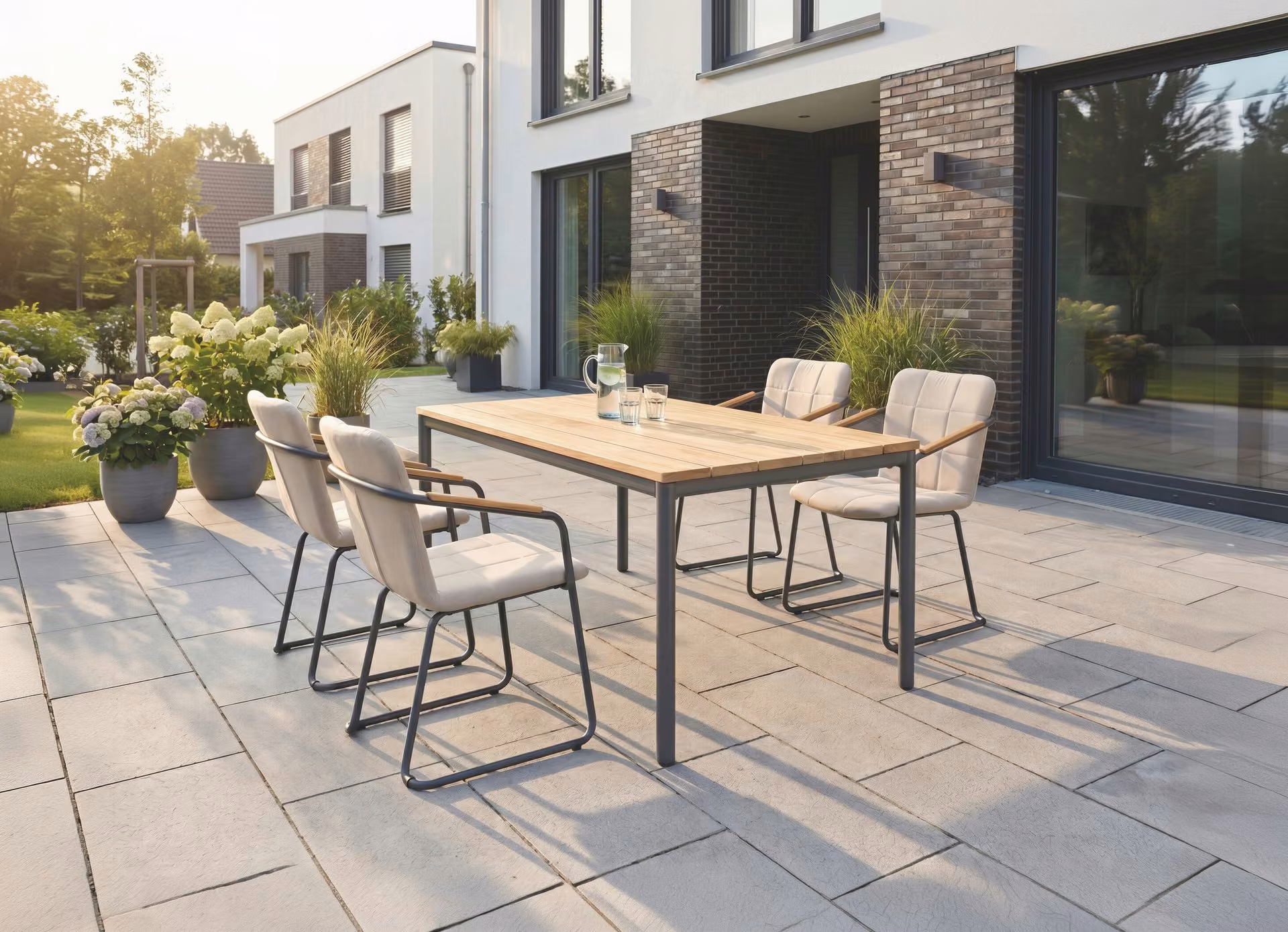 GENTLE Dining-Sessel natte linen mit GENTLE Tischgestell und Teak-Tischplatte auf der Terrasse