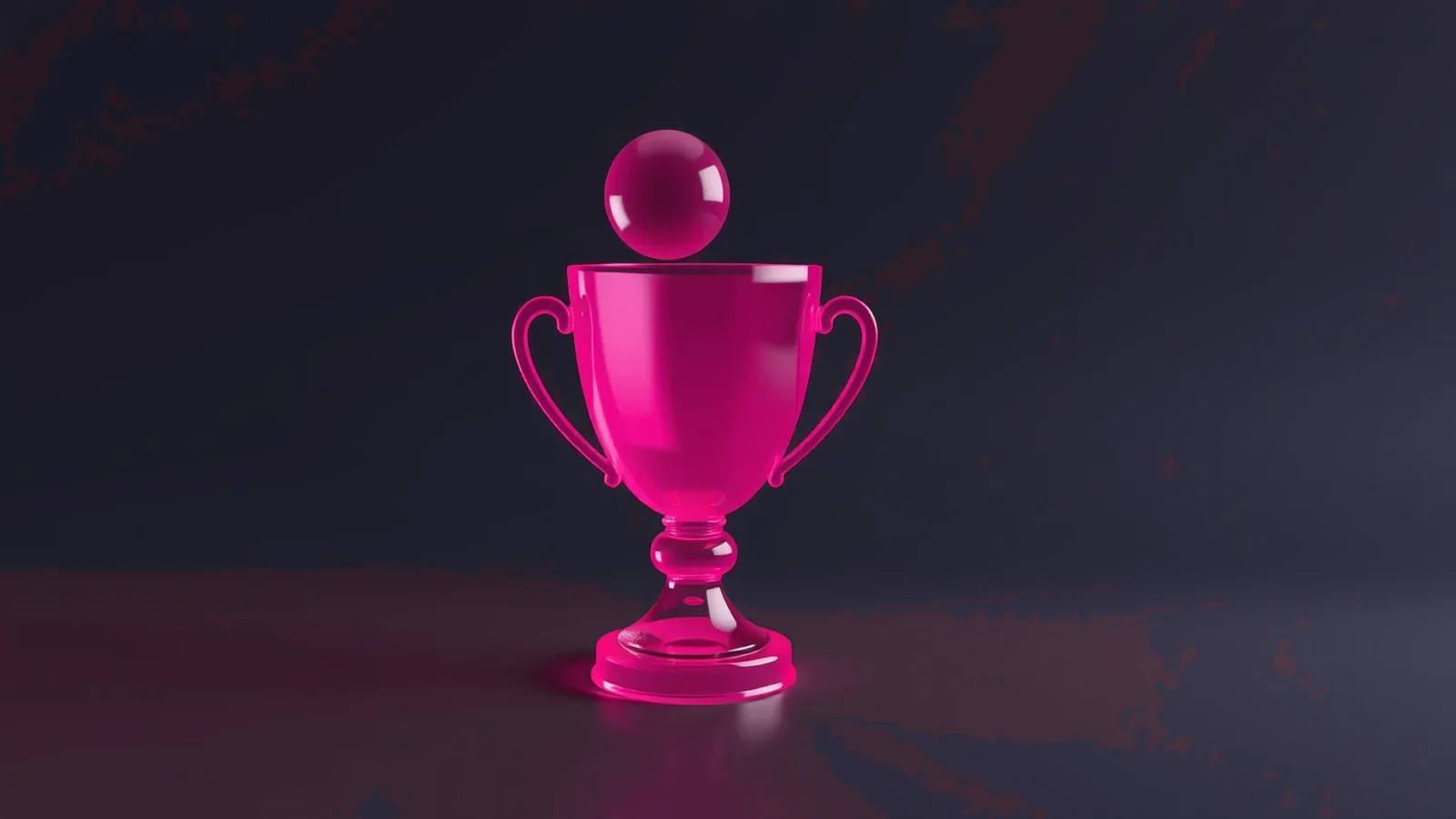 Pink glass trophy cup with a small sphere on top, on a dark background.
