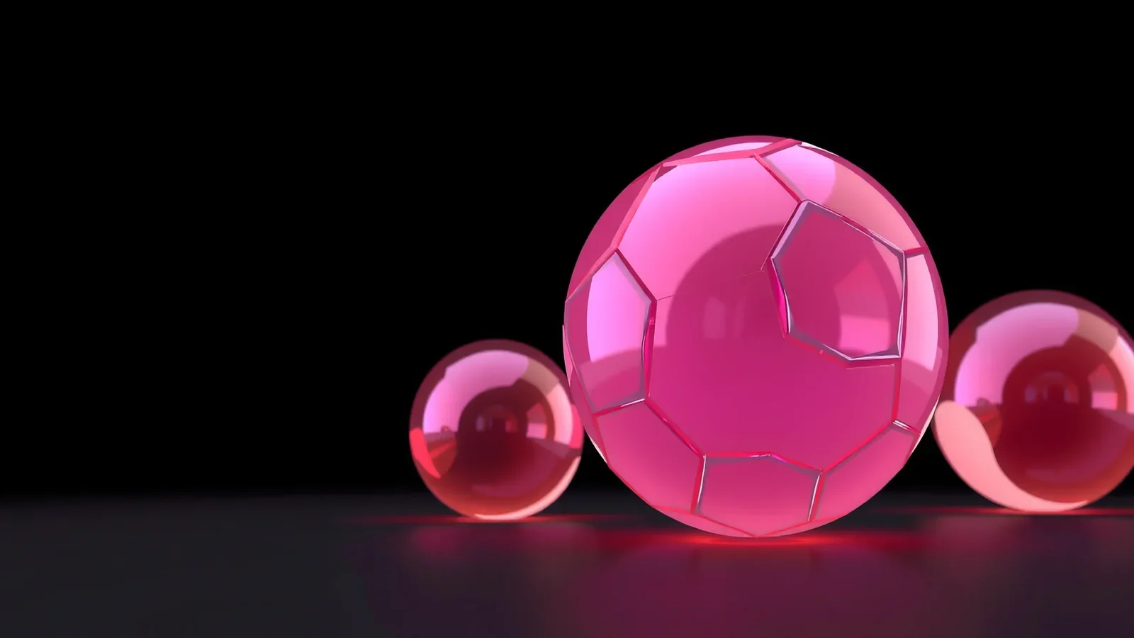 Pink glass sphere composed of fitted segments with two smaller spheres on a black background.