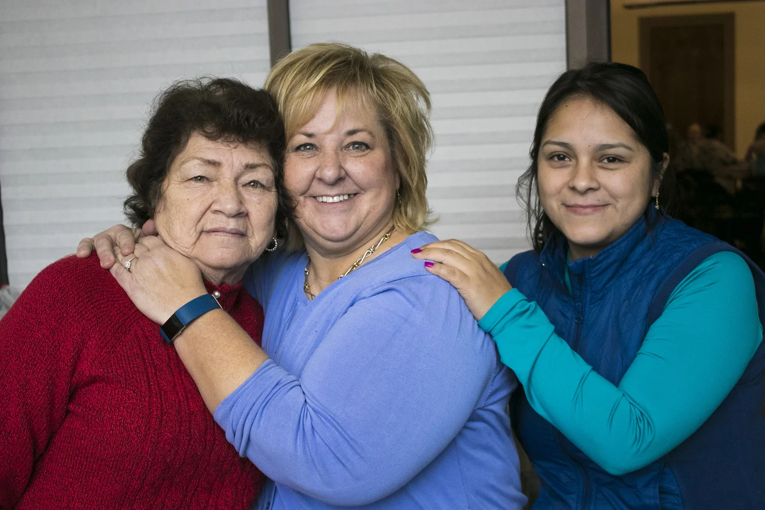 Three women, resting their hands on one another's shoulders smiling, from Heart Felt Tidbits.