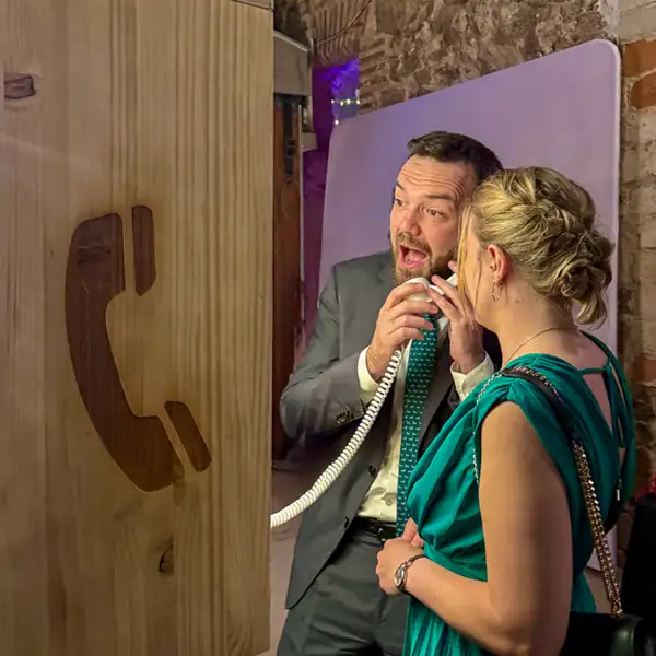 Invitados utilizando un teléfono de mensajes de audio en una boda