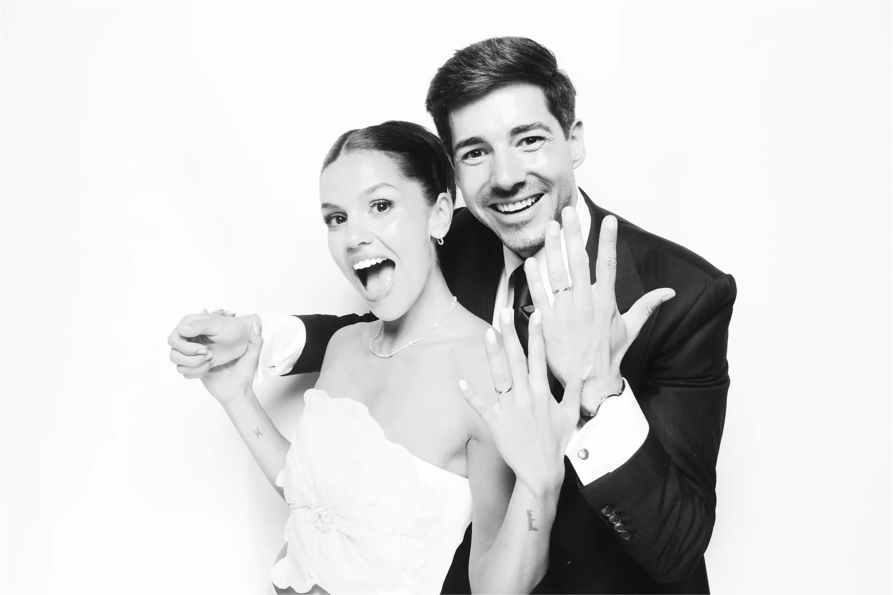 Newlyweds celebrating in a bright editorial-style photo booth portrait.