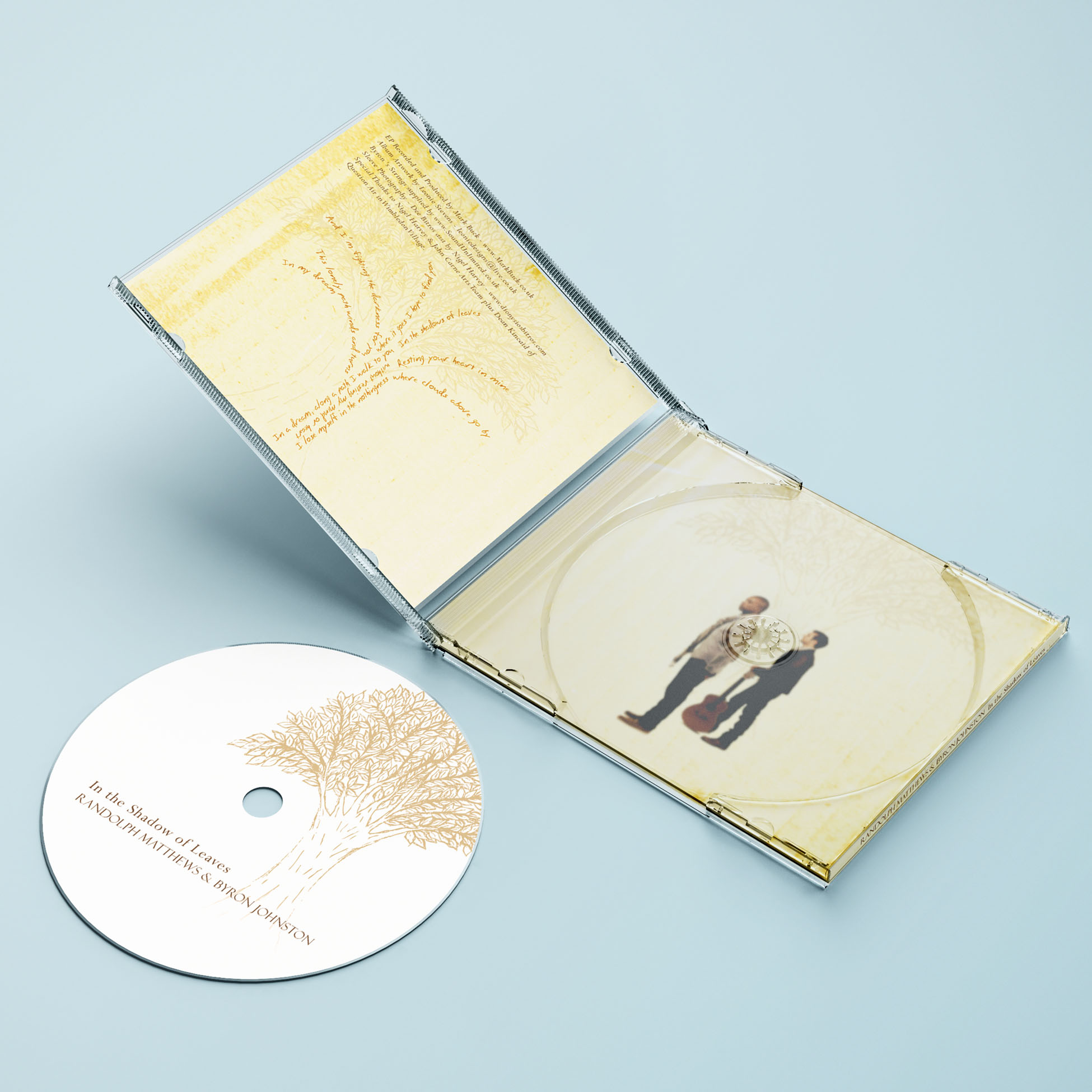 CD case open on a surface, showing the artwork for the back of the booklet and tray inlay. A white CD with an illustrated tree is placed separately