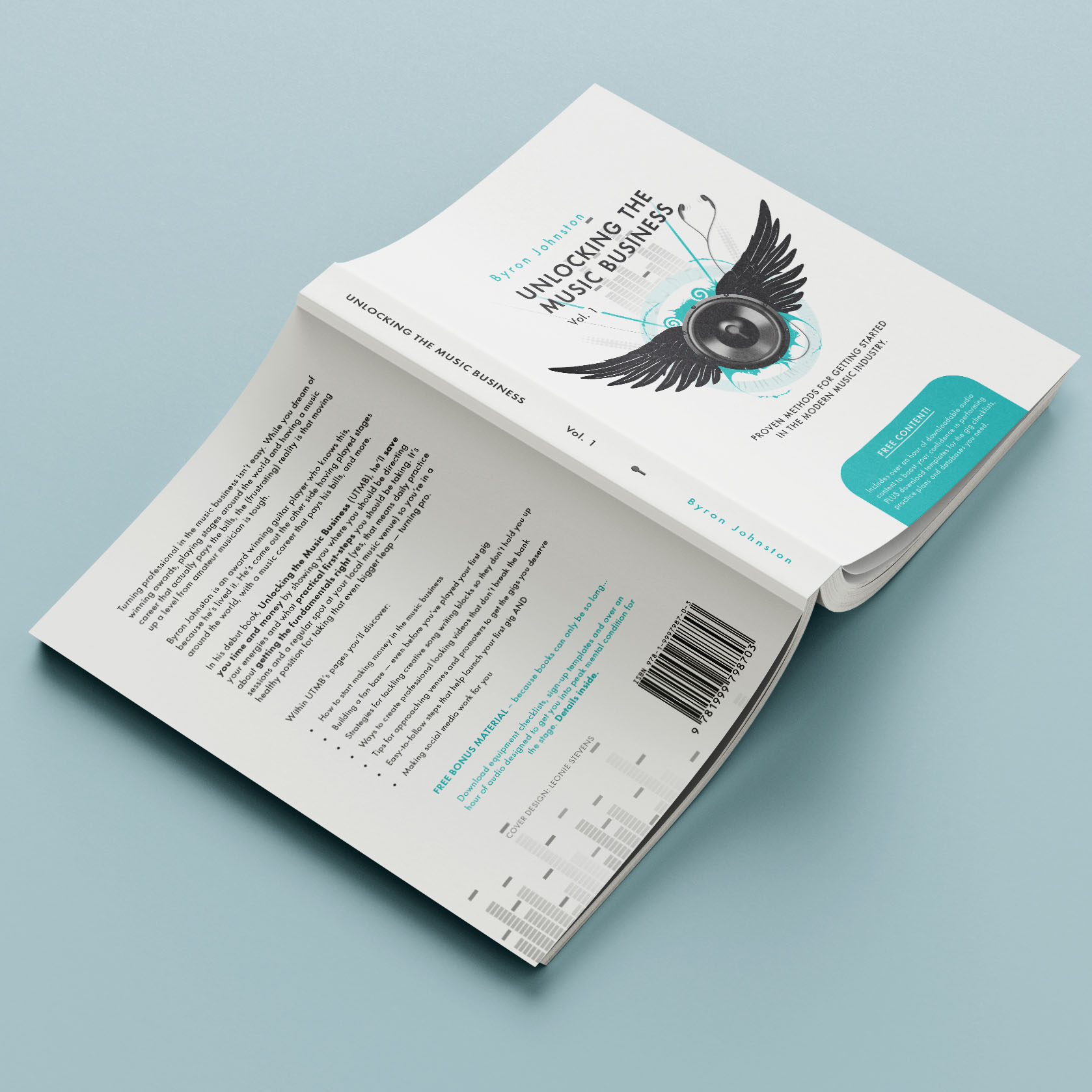 An open book face-down on a surface, showing the front, back, and spine design. The cover features a digitally illustrated speaker with wings, surrounded by musical elements like a digitiser, headphones, and musical notes.